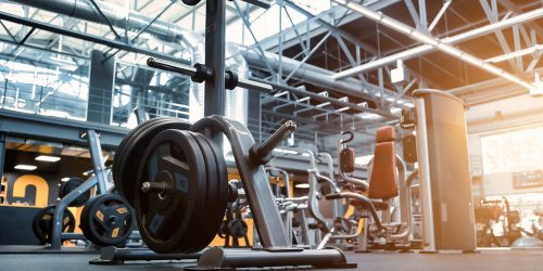 Modern fitness center with members exercising and equipment illustrating insurance considerations for gyms and health clubs.