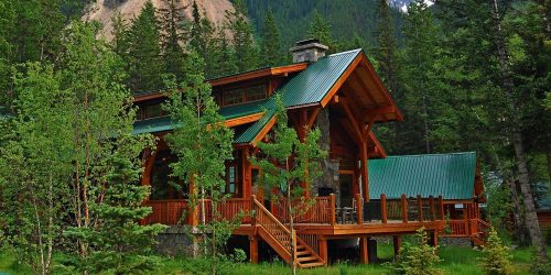 Wildfire prevention measures around a hunting lodge with cleared defensible space and surrounding forest landscape